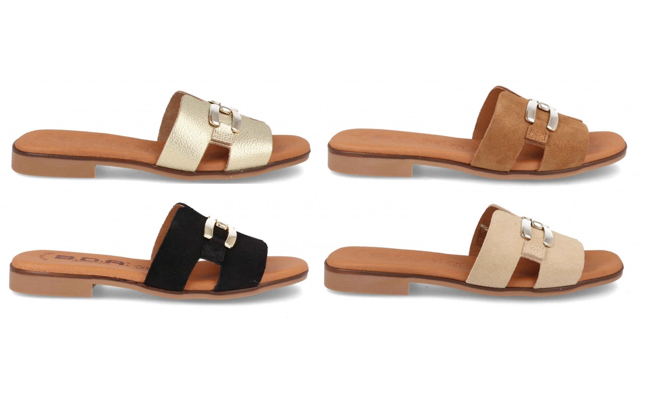 Cuatro variantes de la sandalia plana de piel modelo 105 con pala en forma de H, detalle de hebilla dorada central y planta de confort acolchada.