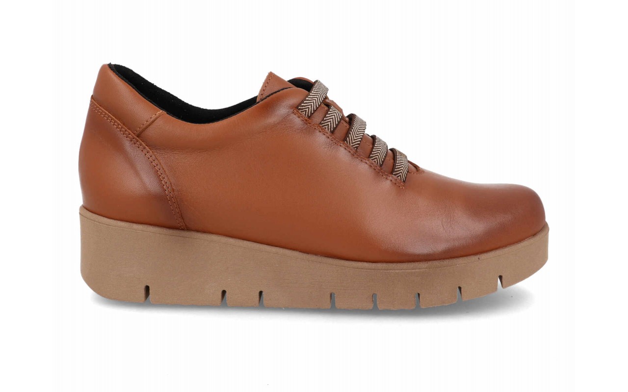 Zapato de piel lisa para mujer modelo 122 con sistema de cordones elásticos decorativos en zigzag y suela de plataforma de poliuretano con relieves.