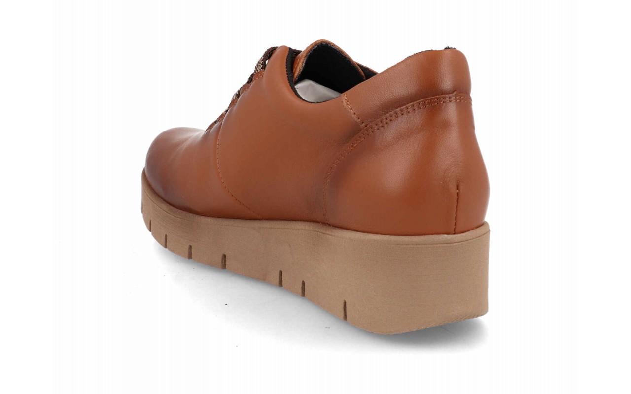 Zapato de piel lisa para mujer modelo 122 con sistema de cordones elásticos decorativos en zigzag y suela de plataforma de poliuretano con relieves.