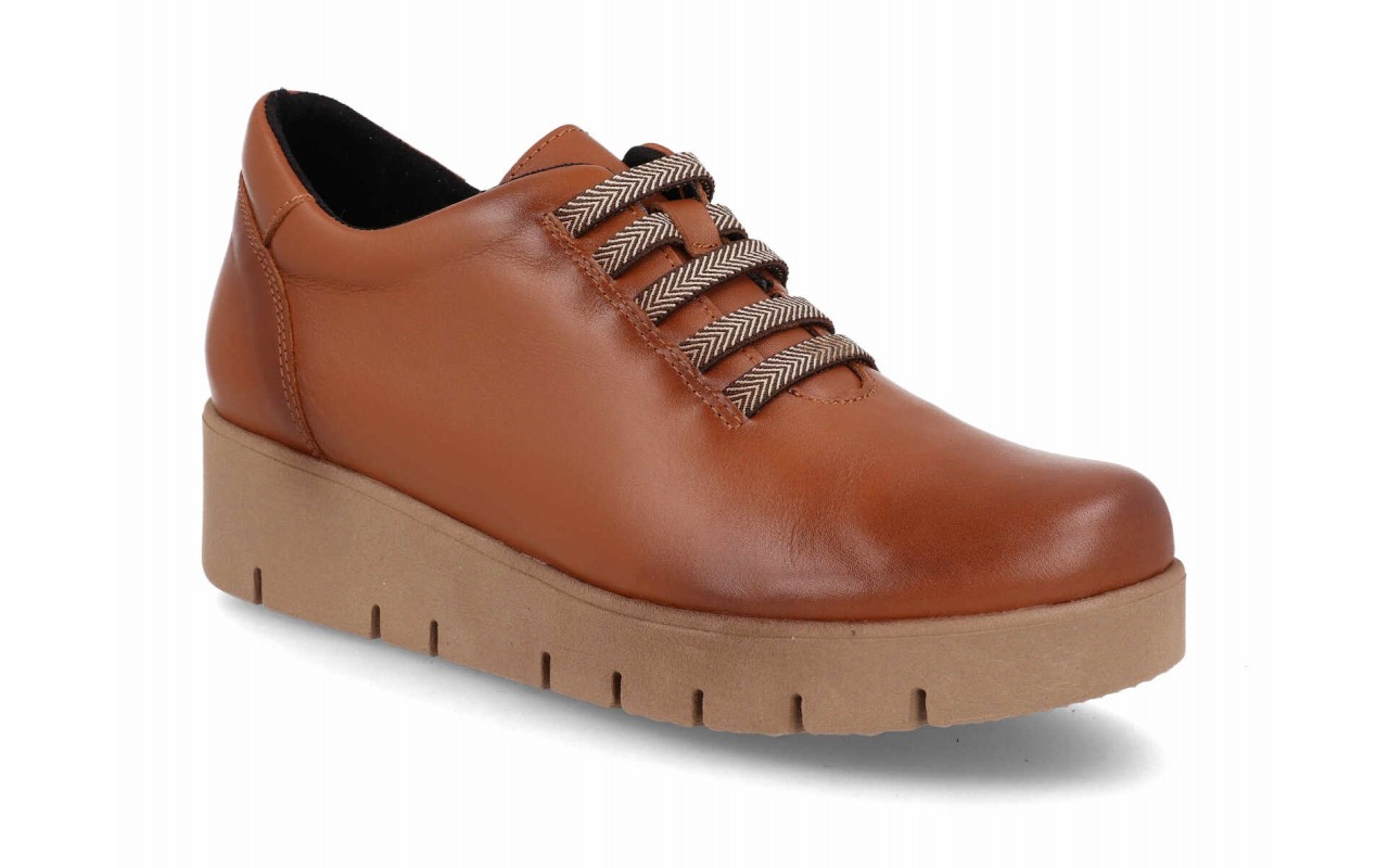 Zapato de piel lisa para mujer modelo 122 con sistema de cordones elásticos decorativos en zigzag y suela de plataforma de poliuretano con relieves.