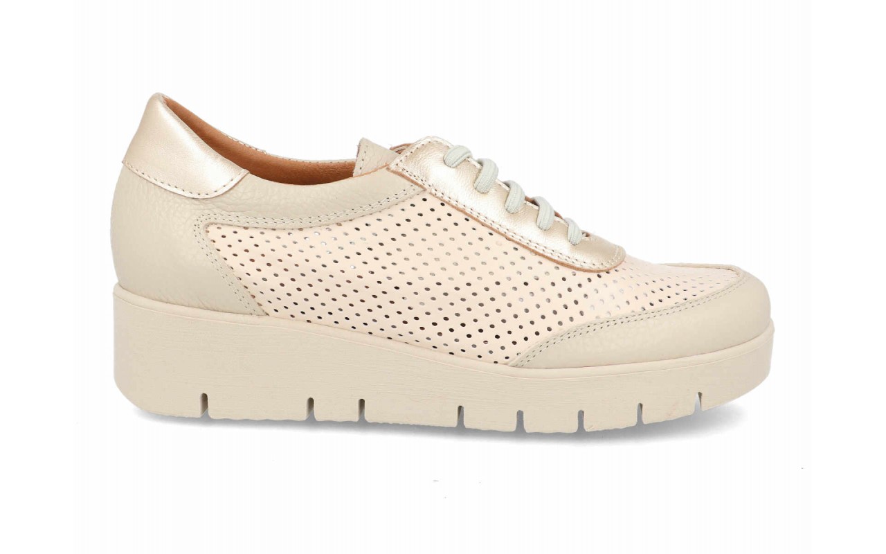 Zapato deportivo de piel para mujer modelo 125 con paneles laterales calados, detalles en el talón de piel metalizada, cordones elásticos y suela de plataforma con relieves.